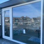 Glaszettersbedrijf Hier is goed zichtbaar hoe de kunststof kozijnen en deur samen één geheel vormen. Dankzij de slanke profielen blijft het glasoppervlak maximaal terwijl de constructie voldoende stabiliteit behoudt.