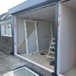 Glaszettersbedrijf Deze foto toont de gevelopening voordat de nieuwe kunststof pui volledig was geplaatst. De voorbereidingsfase is cruciaal om een perfecte aansluiting en langdurige waterdichtheid te garanderen.